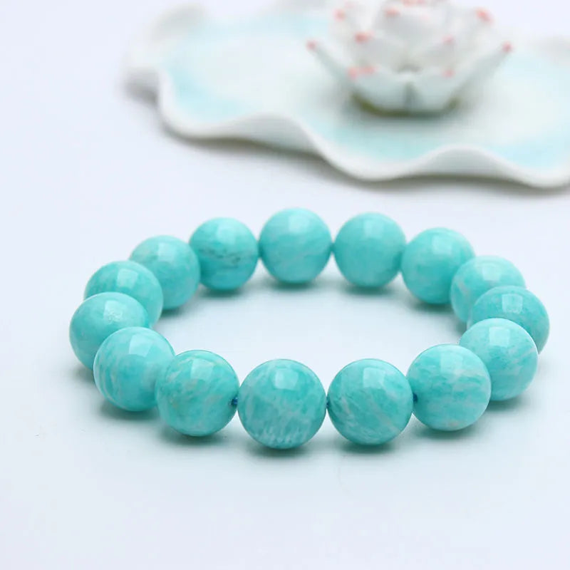 Blue-green amazonite gemstone bracelet with round beads on a black elastic cord.