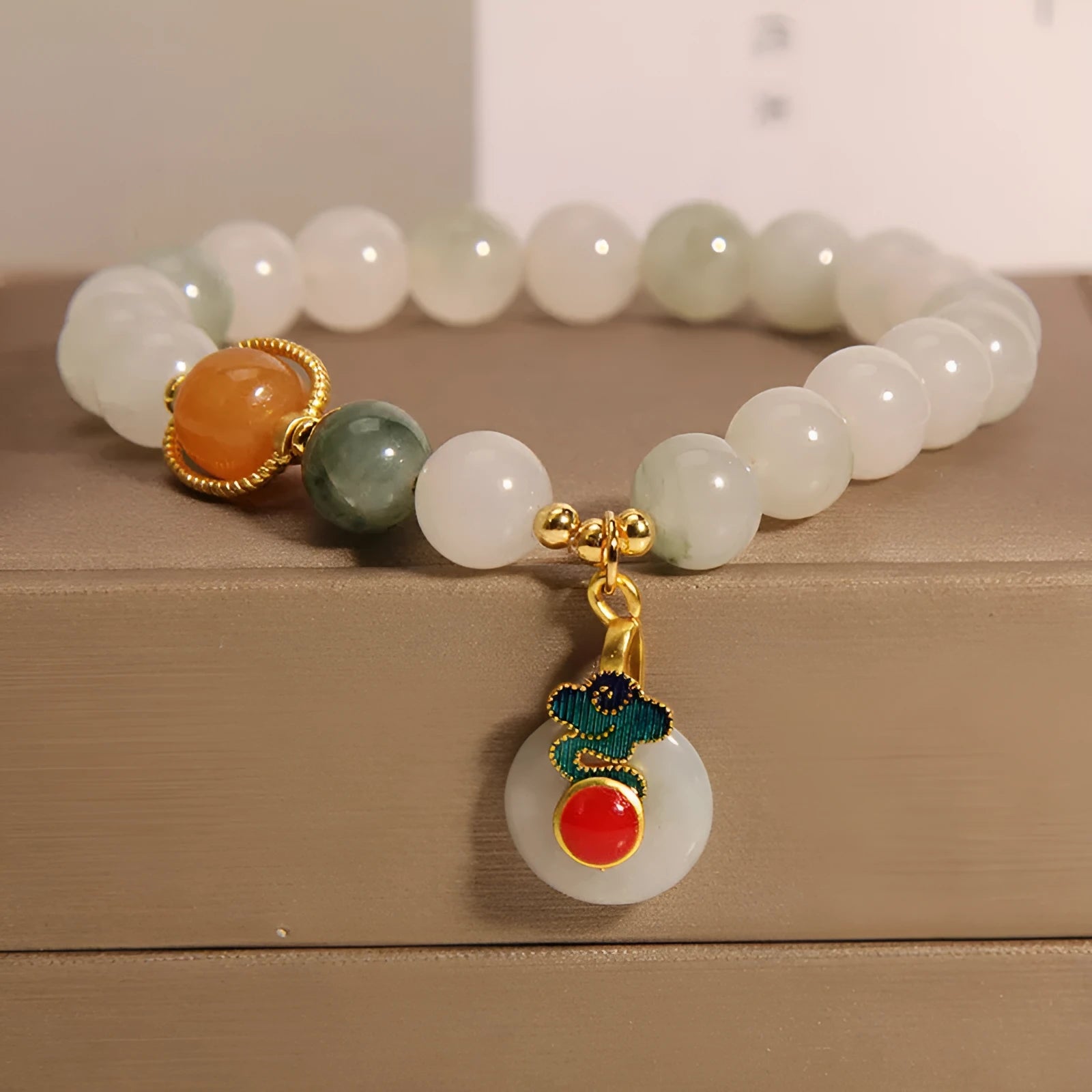 Women's ice jade bracelet with xiangyun pattern, peace buckle, and pearl accents on a white background.