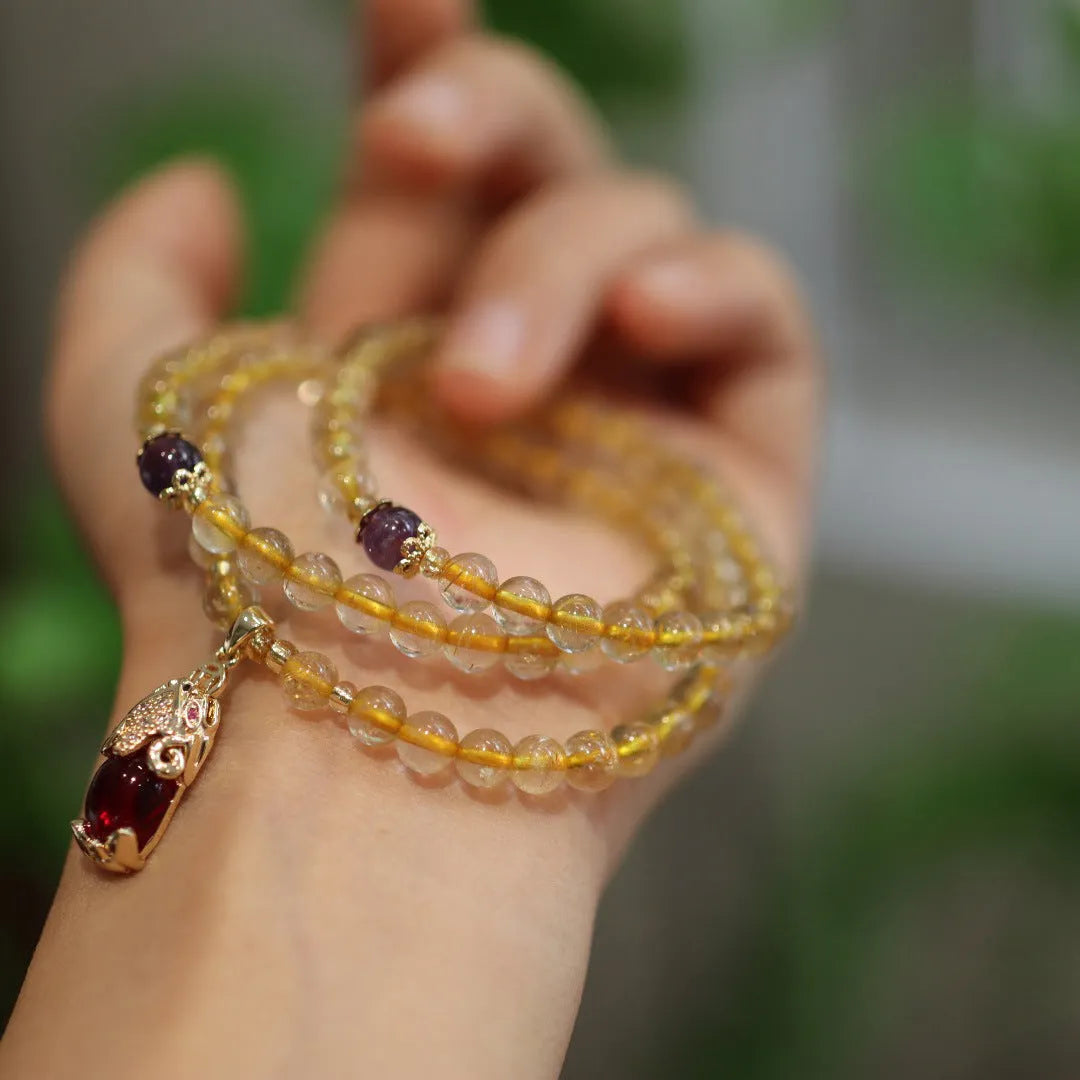 Handmade natural gold rutilated quartz bracelet in Chinese three-ring style with hanging chopsticks.