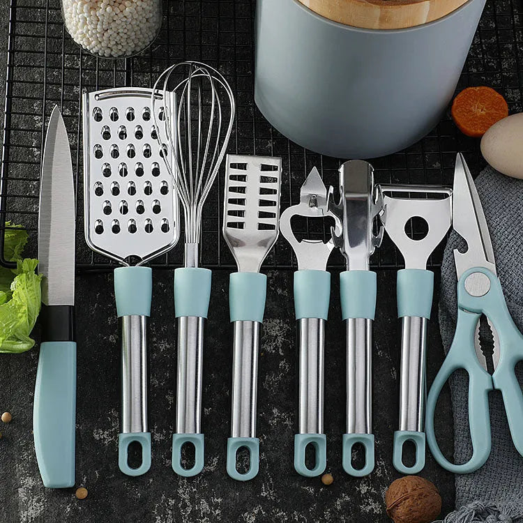 Stainless steel kitchen gadgets set with whisk, peeler, scissors, and fruit knife on grey tray