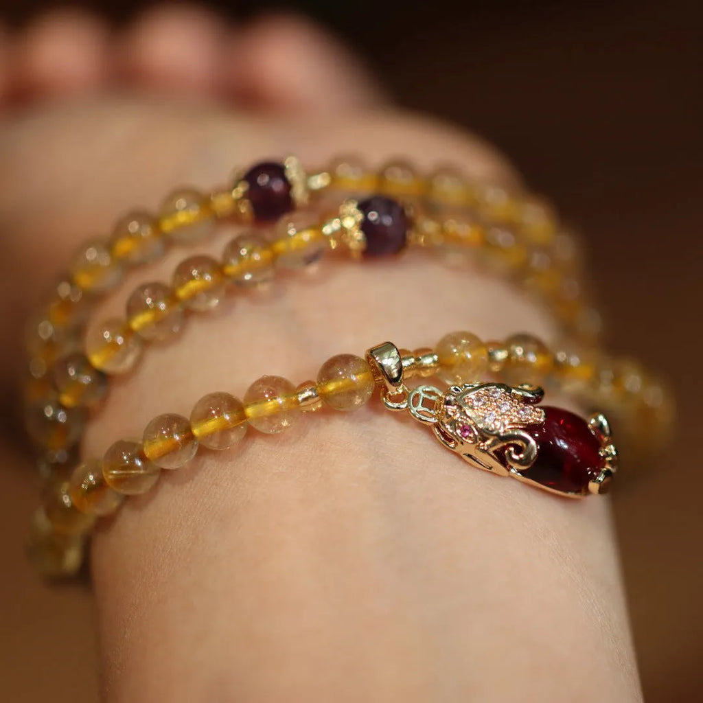 Handmade natural gold rutilated quartz bracelet in Chinese three-ring style with hanging chopsticks.