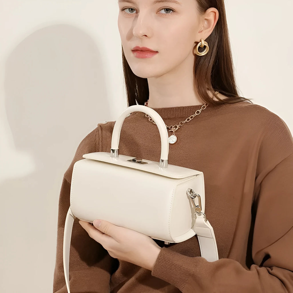 Structured leather women's crossbody bag in a clamshell design, shown in one of four colour options.