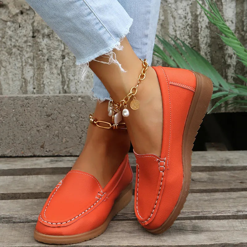 Women's flat loafer shoe in PU leather with car suture detail and a round toe, shown in a choice of colours.