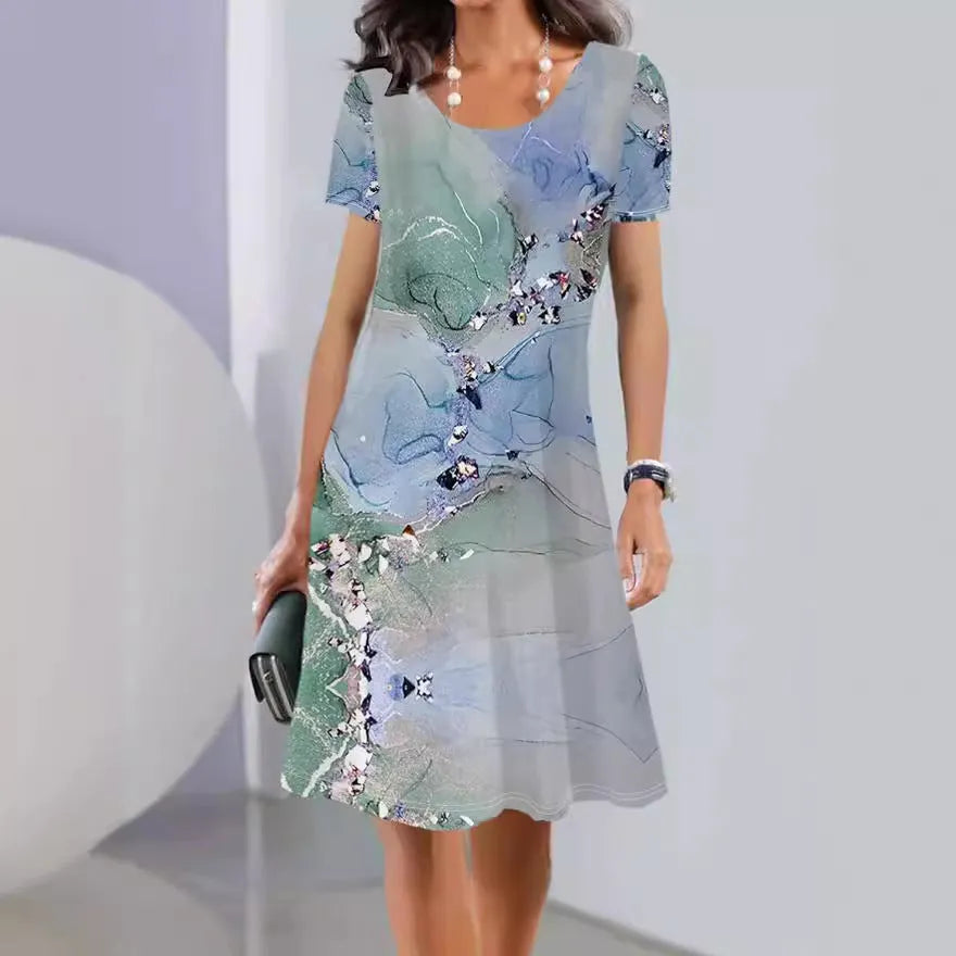 Light blue mid-length dress with white plants and flowers print, A-line skirt, and short sleeves.