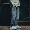 Man wearing blue loose straight-leg stretch denim trousers for a casual retro look.