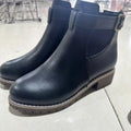 Black round toe ankle boot with a silver belt buckle decoration on the side.
