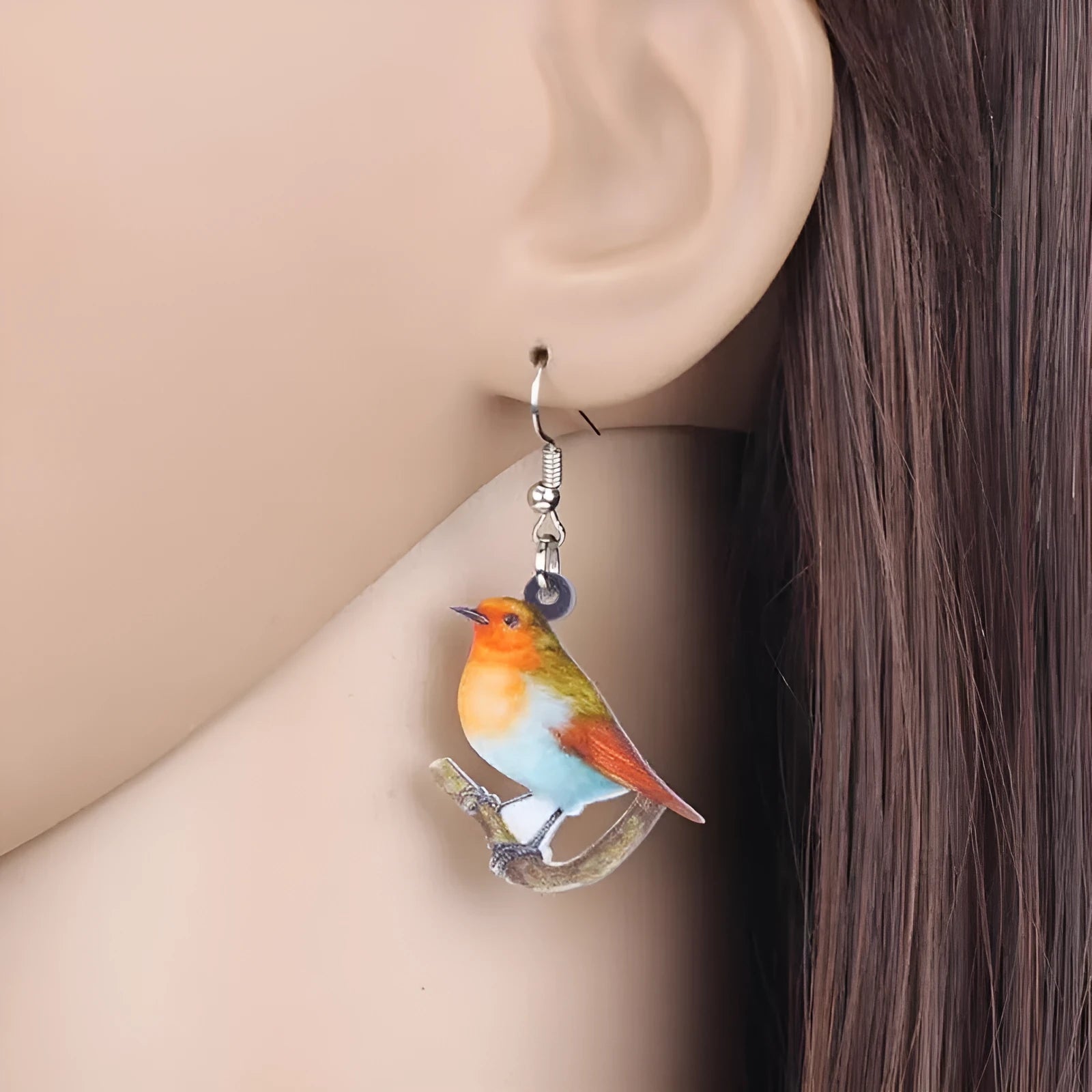 A pair of blue titmouse pendant earrings made from printed acrylic with a geometric, animal-inspired design.