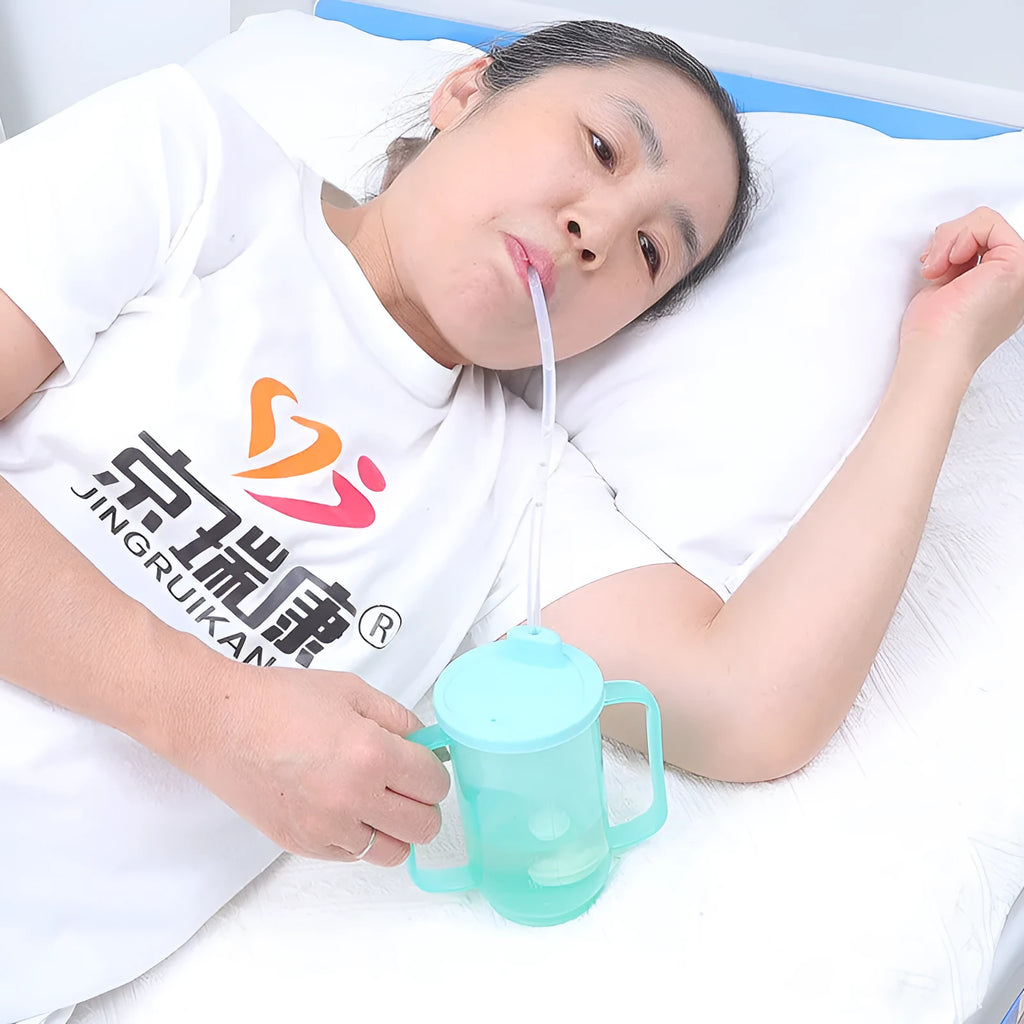 Adult choke-proof drinking cup with handle and slanted lid for bedside use.