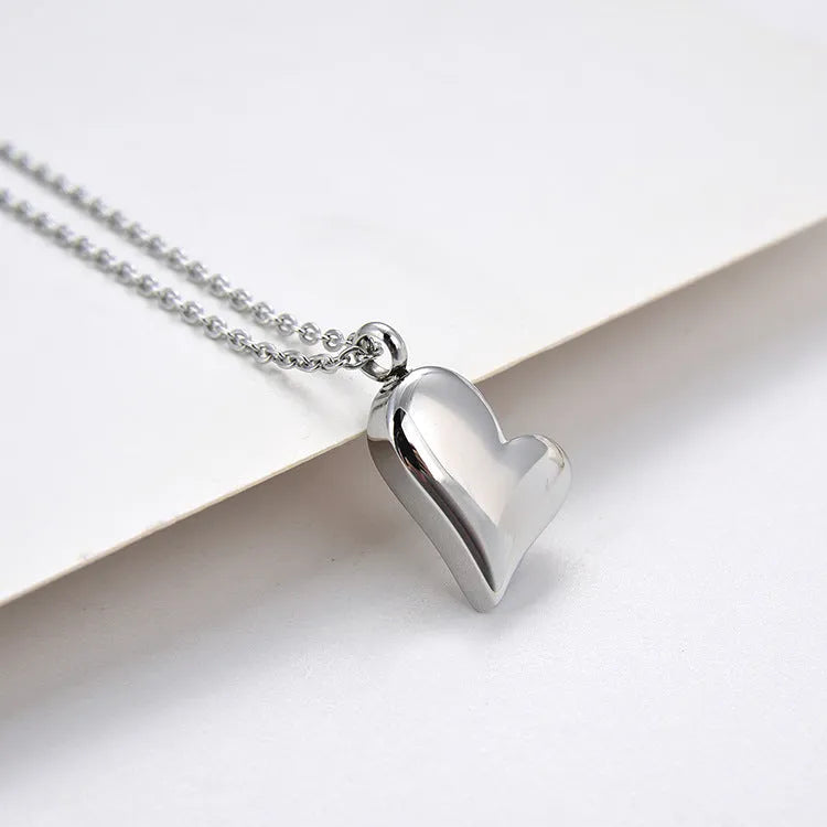 Silver curved peach heart pendant necklace on a chain with extension