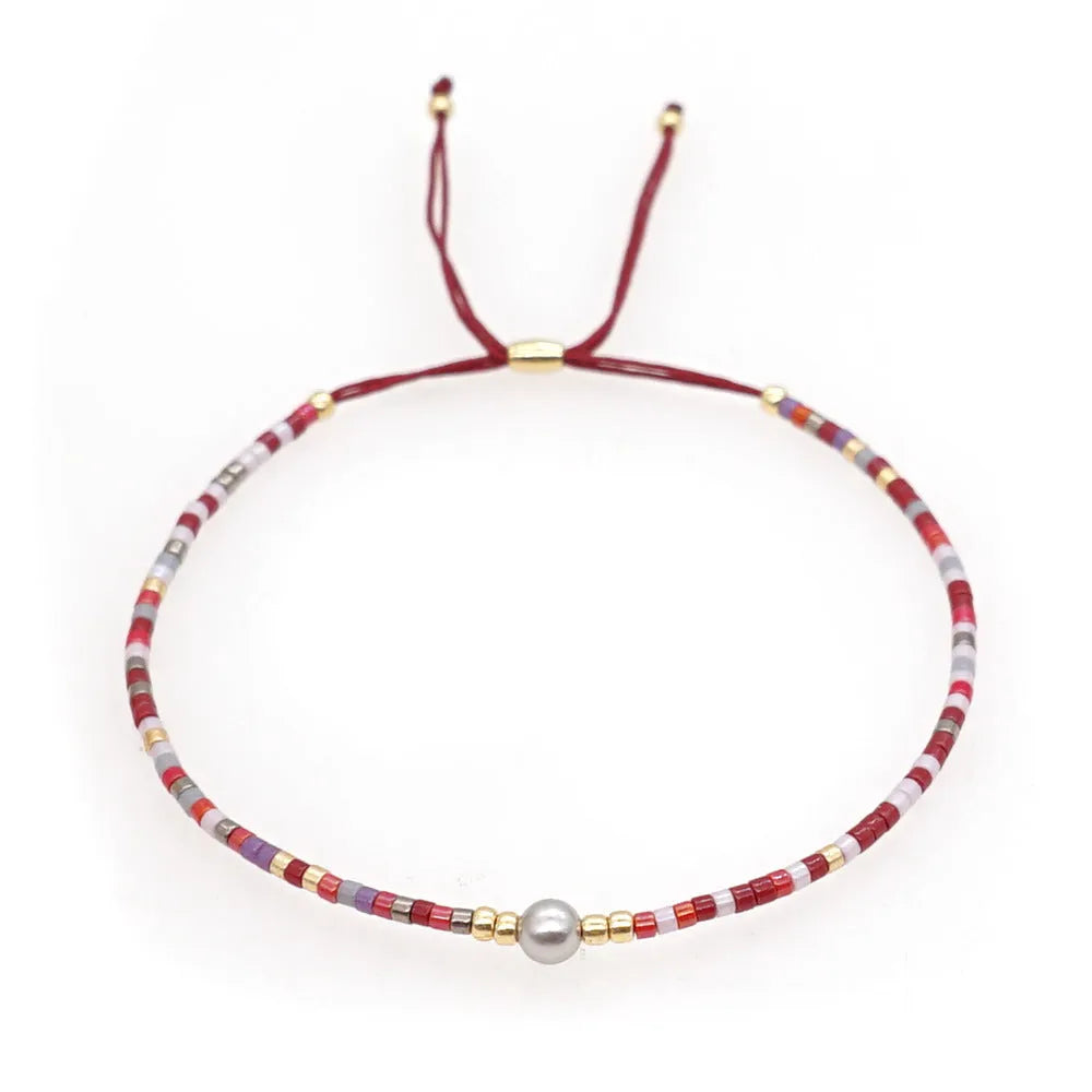 Handmade glass beaded bracelet with geometric design and semi-precious stone lucky bead charm