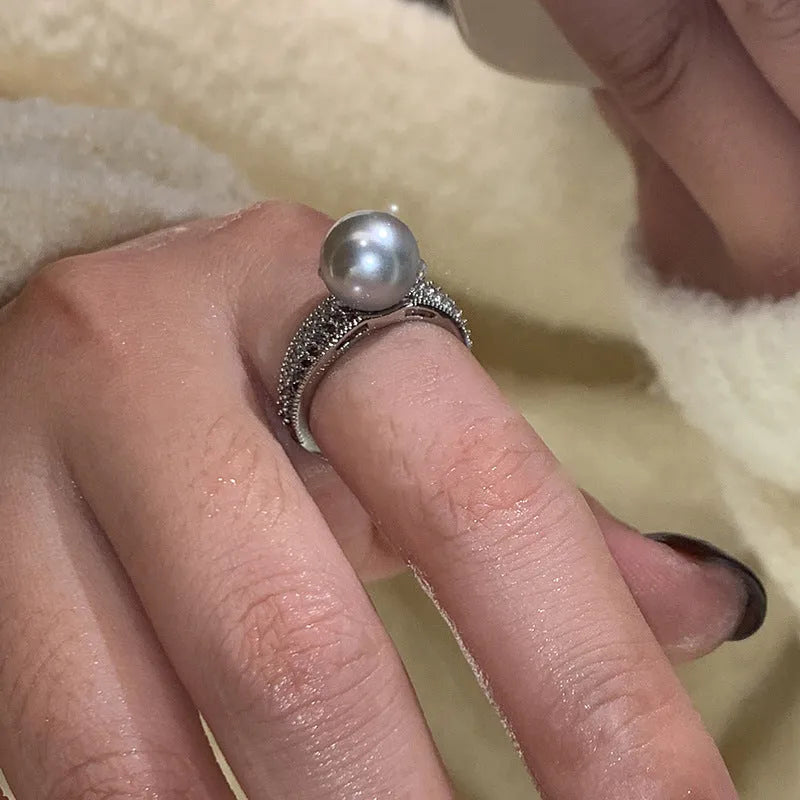 Adjustable geometric copper ring for women with a black pearl on an open band.