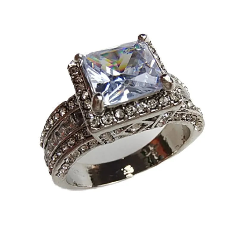 Geometric women's silver fashion ring with round details in gold or white electroplated finish on a finger.