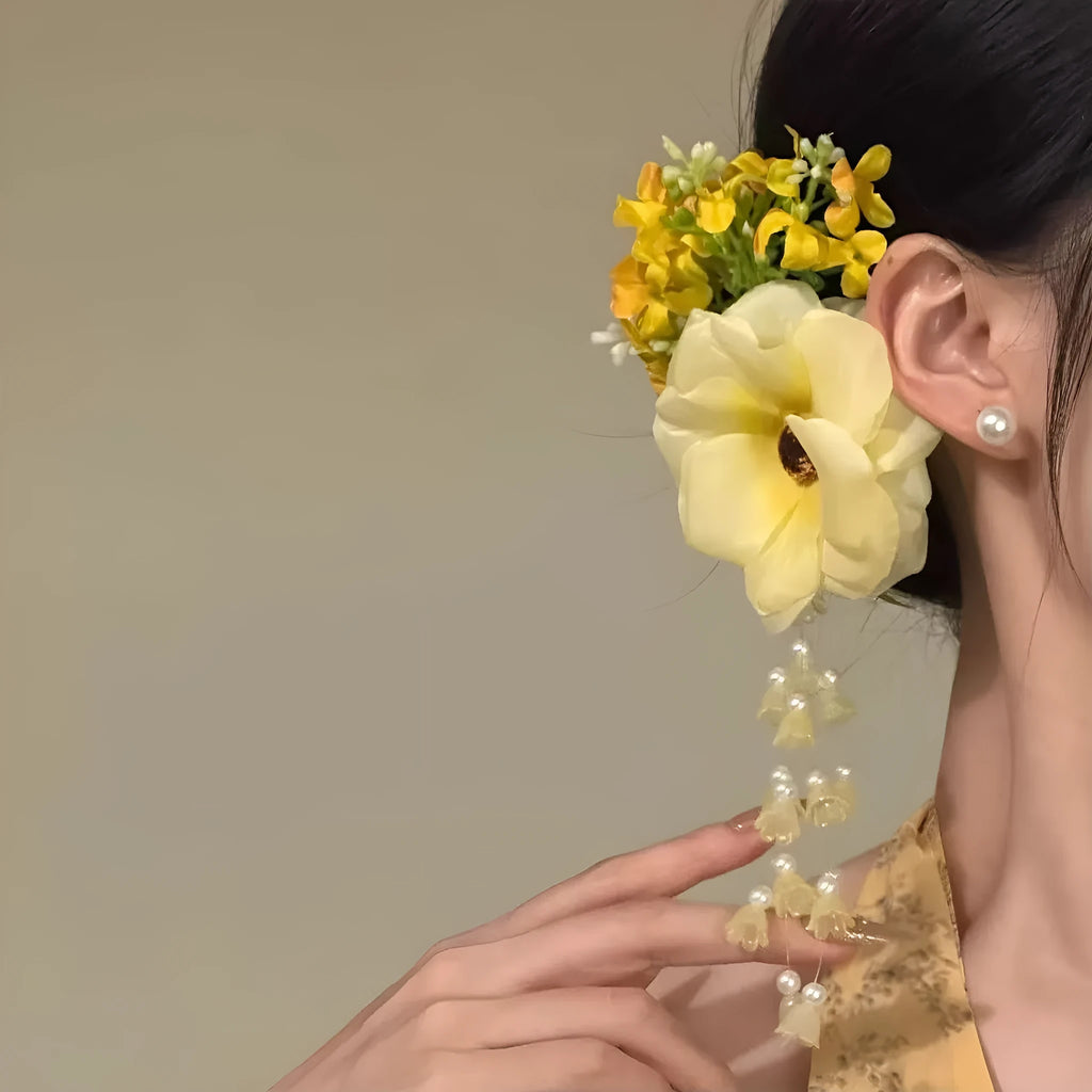 Close-up of a women's floral tassel hair clip with a side clip, shown in yellow and purple colour options.