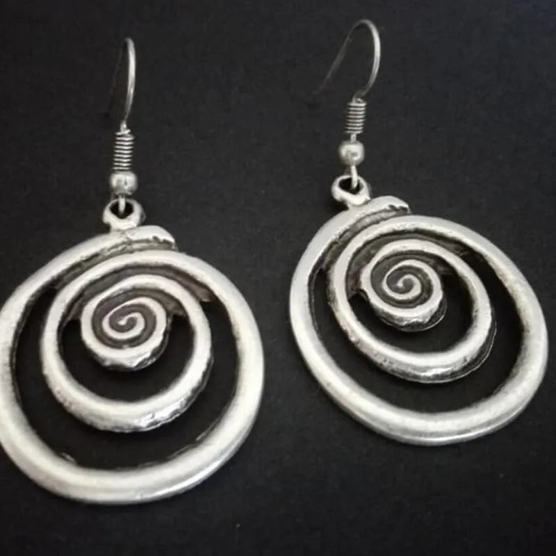 Silver geometric spiral distressed retro style earrings with a folk art design