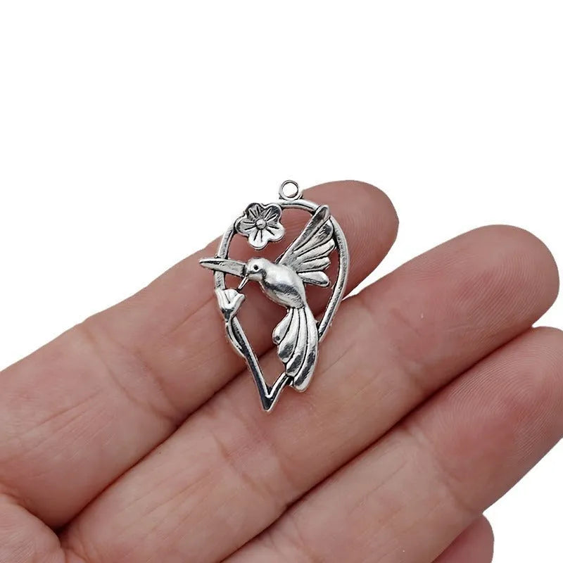 Close-up of a silver-toned alloy cuckoo bird pendant with a magpie pattern, for DIY jewellery making.