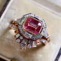 Rose gold coloured alloy women's ring with a geometric retro design and ruby-style details on a white background.