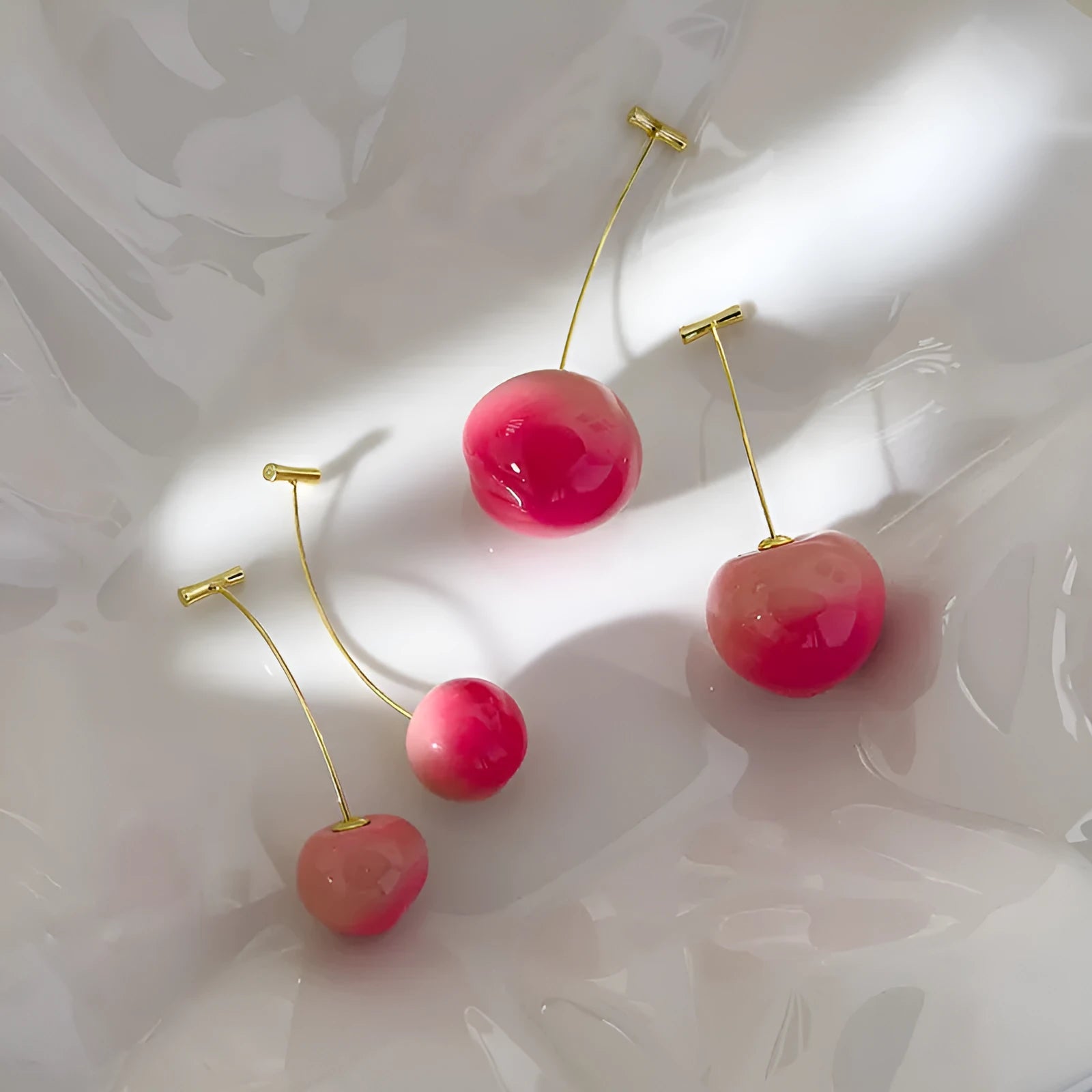 A pair of peach-shaped acrylic earrings on copper posts, shown in small and large size options.