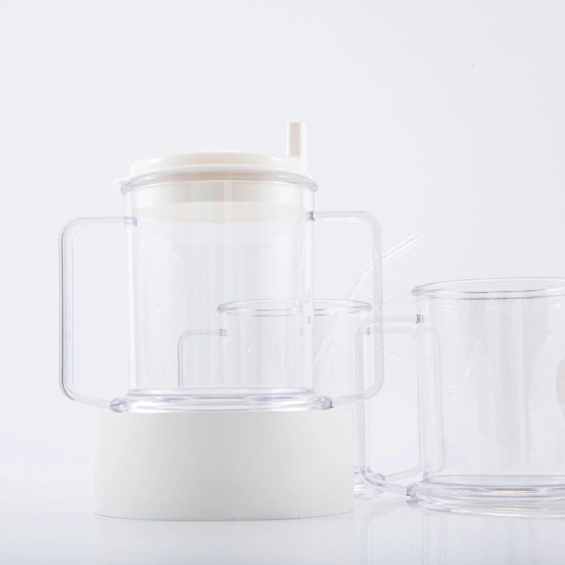 Transparent spill-proof drinking cup with straw lid showing modern minimalist design