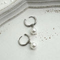 Geometric pearl drop earrings with titanium steel alloy construction and round element accents