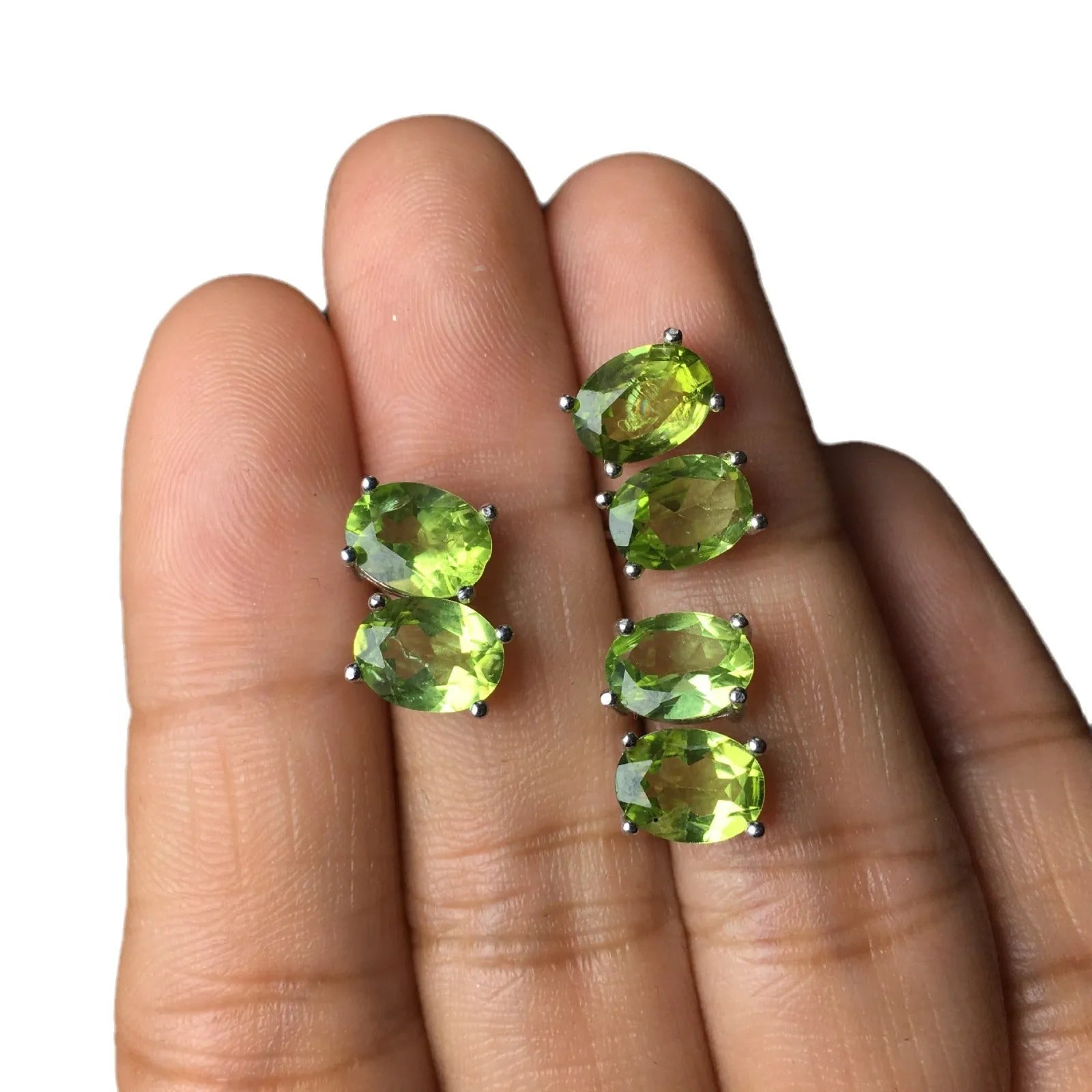Close-up of grass green natural olivine faceted stud earrings in S925 silver geometric setting.