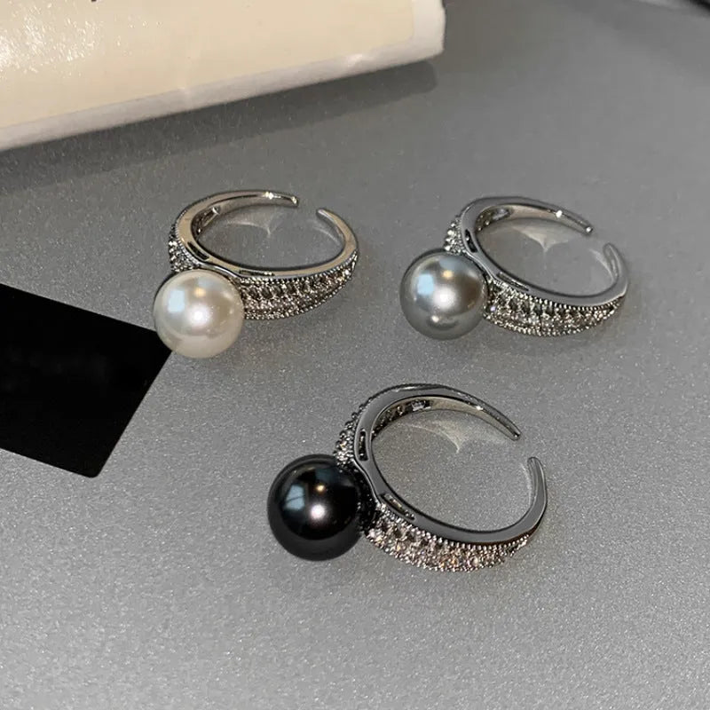 Adjustable geometric copper ring for women with a black pearl on an open band.