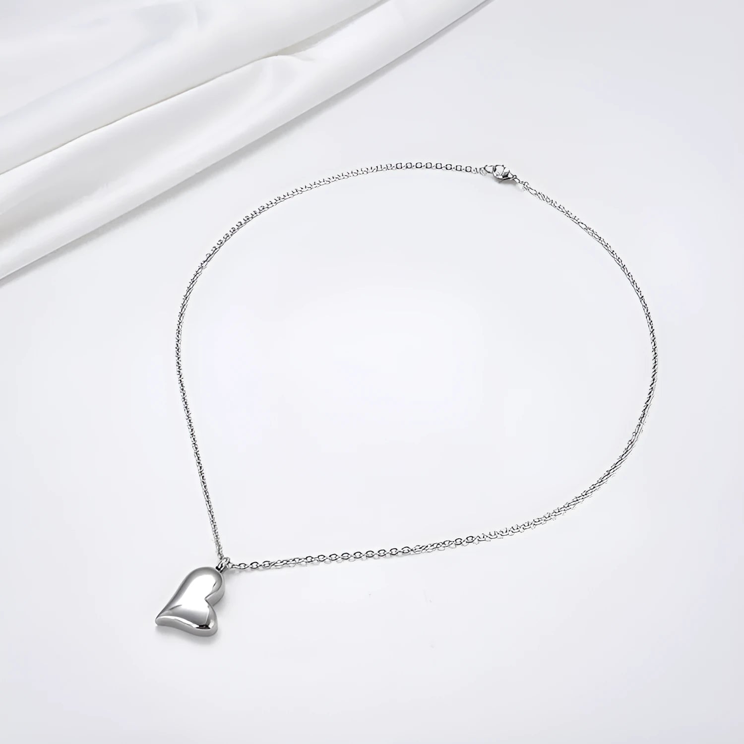 Silver curved peach heart pendant necklace on a chain with extension