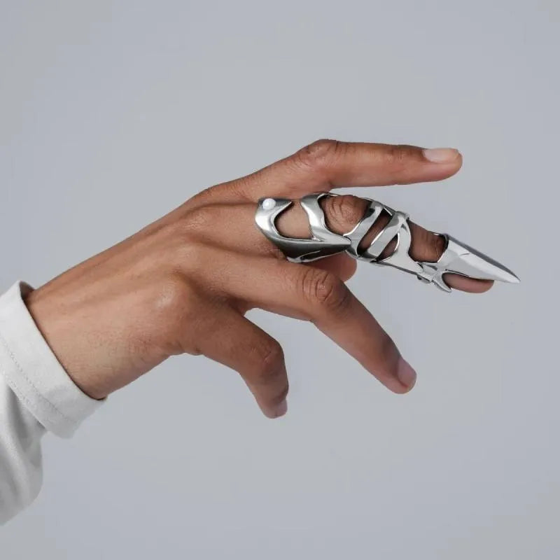Silver-coloured alloy finger stall with a punk armour design.