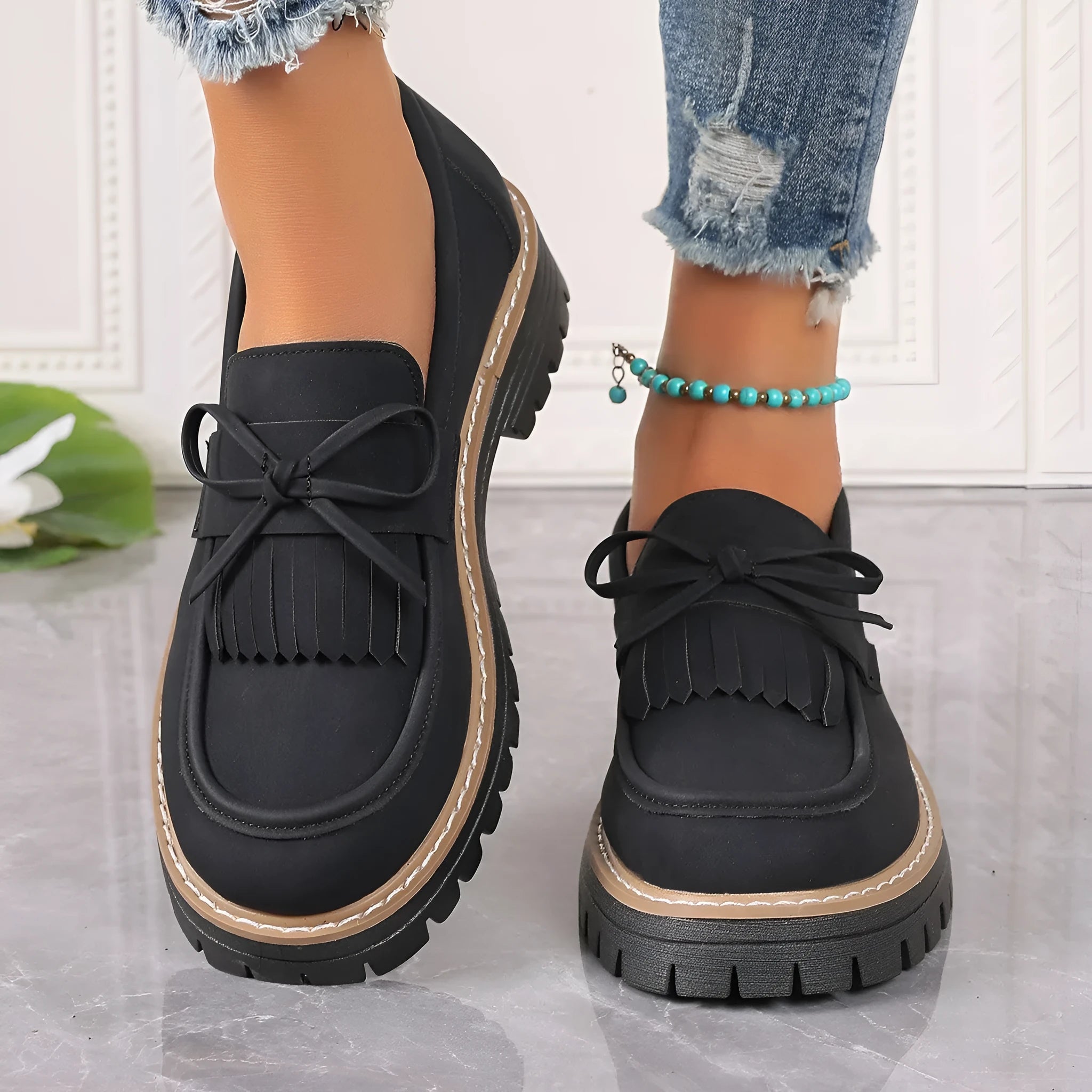 Black faux leather women's loafers with a tassel decoration and a thick chunky heel