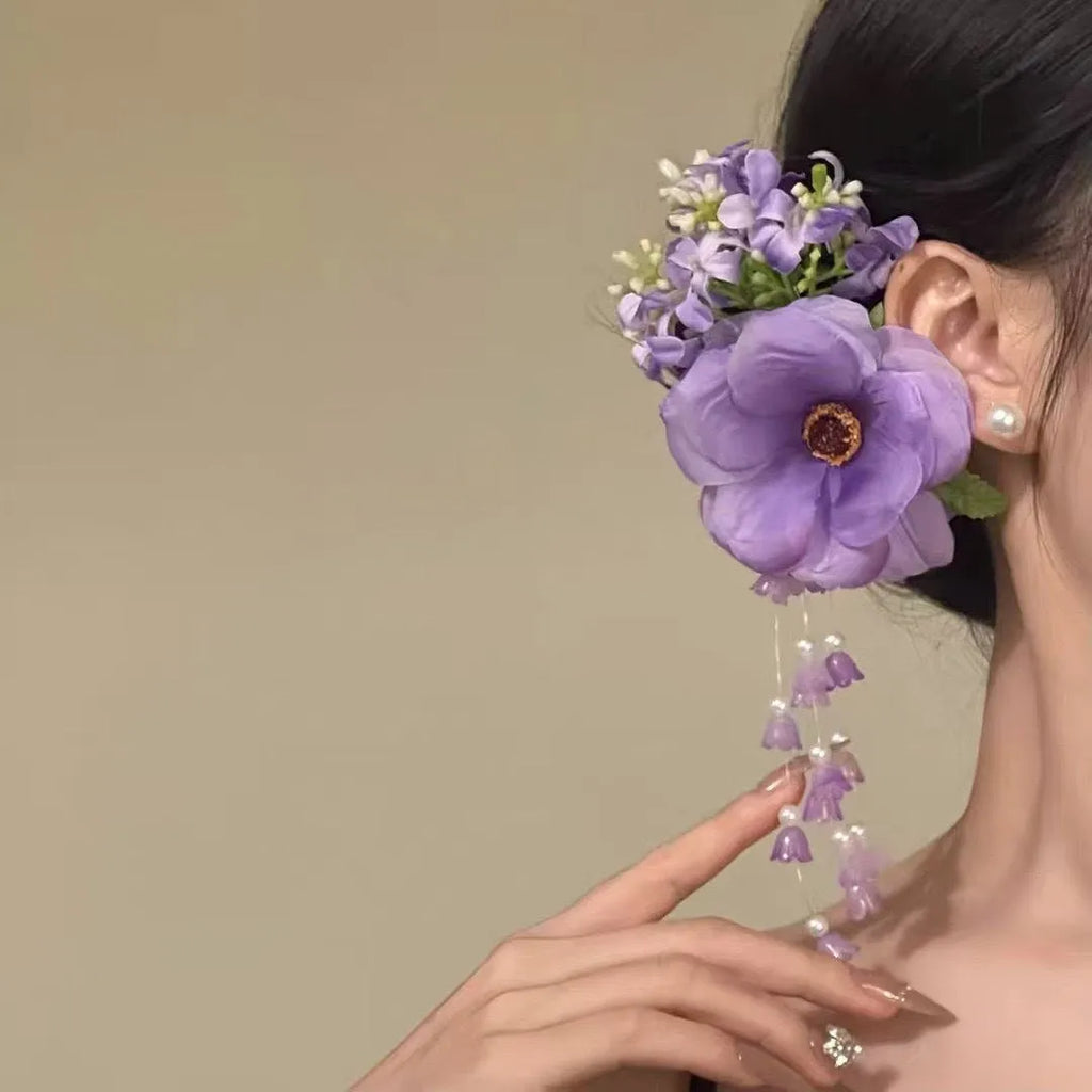 Close-up of a women's floral tassel hair clip with a side clip, shown in yellow and purple colour options.