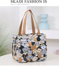 Women's printed canvas handbag with aluminium frame in a horizontal square shape, shown in a floral design.