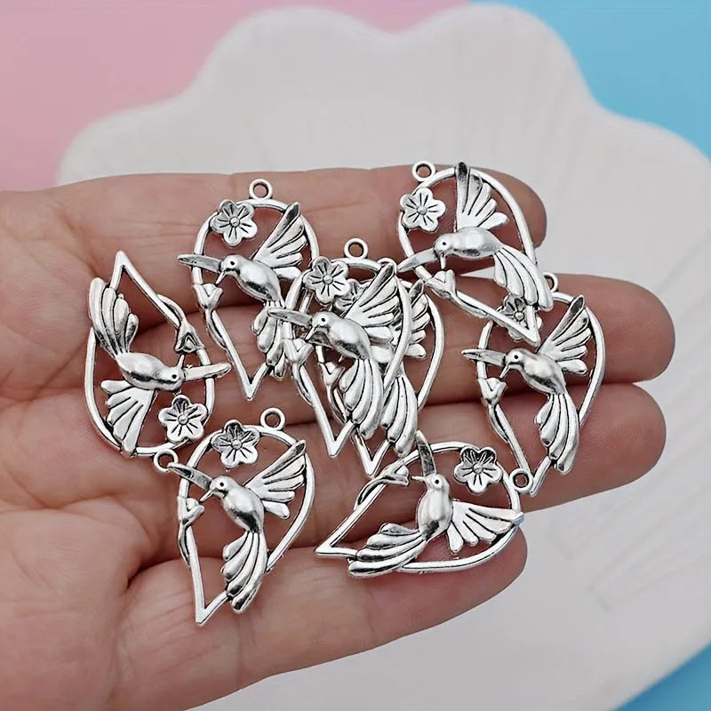 Close-up of a silver-toned alloy cuckoo bird pendant with a magpie pattern, for DIY jewellery making.