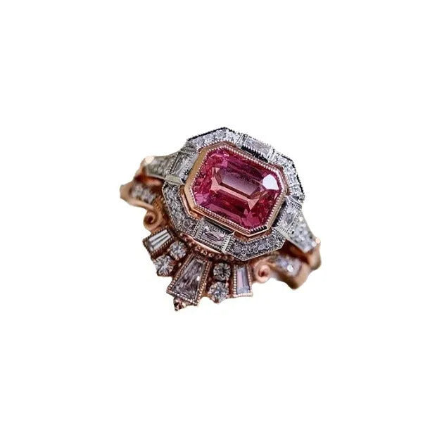 Rose gold coloured alloy women's ring with a geometric retro design and ruby-style details on a white background.