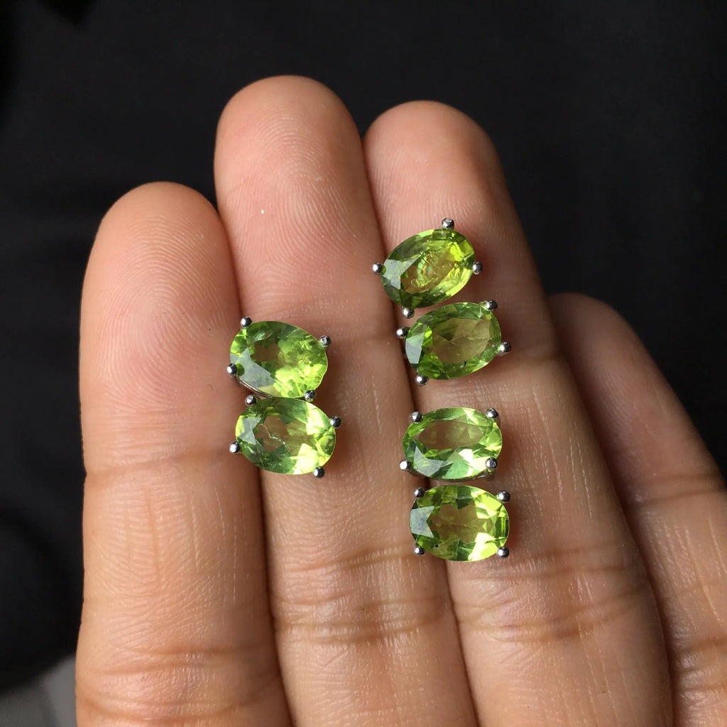 Close-up of grass green natural olivine faceted stud earrings in S925 silver geometric setting.