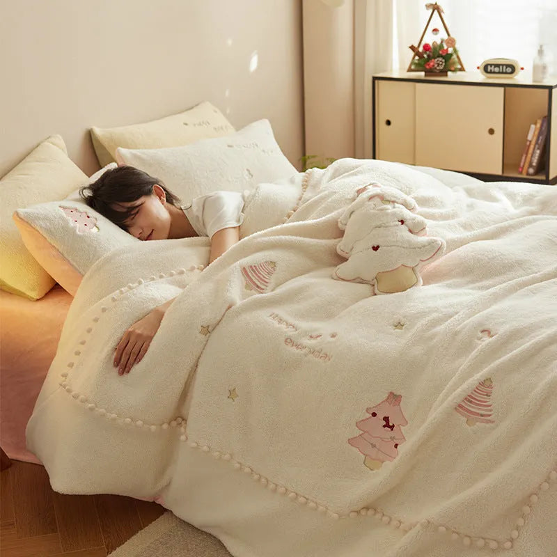 Winter milk fibre four-piece bedding set with printed green Christmas tree pattern on a bed.