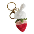 Hand-woven white doll wire rabbit strawberry pendant on a key chain.