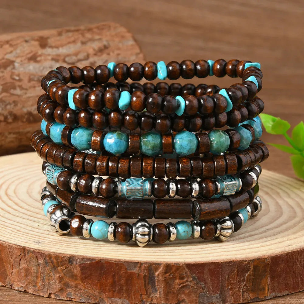 Seven multicoloured retro bracelets with wooden beads and alloy metal components arranged together
