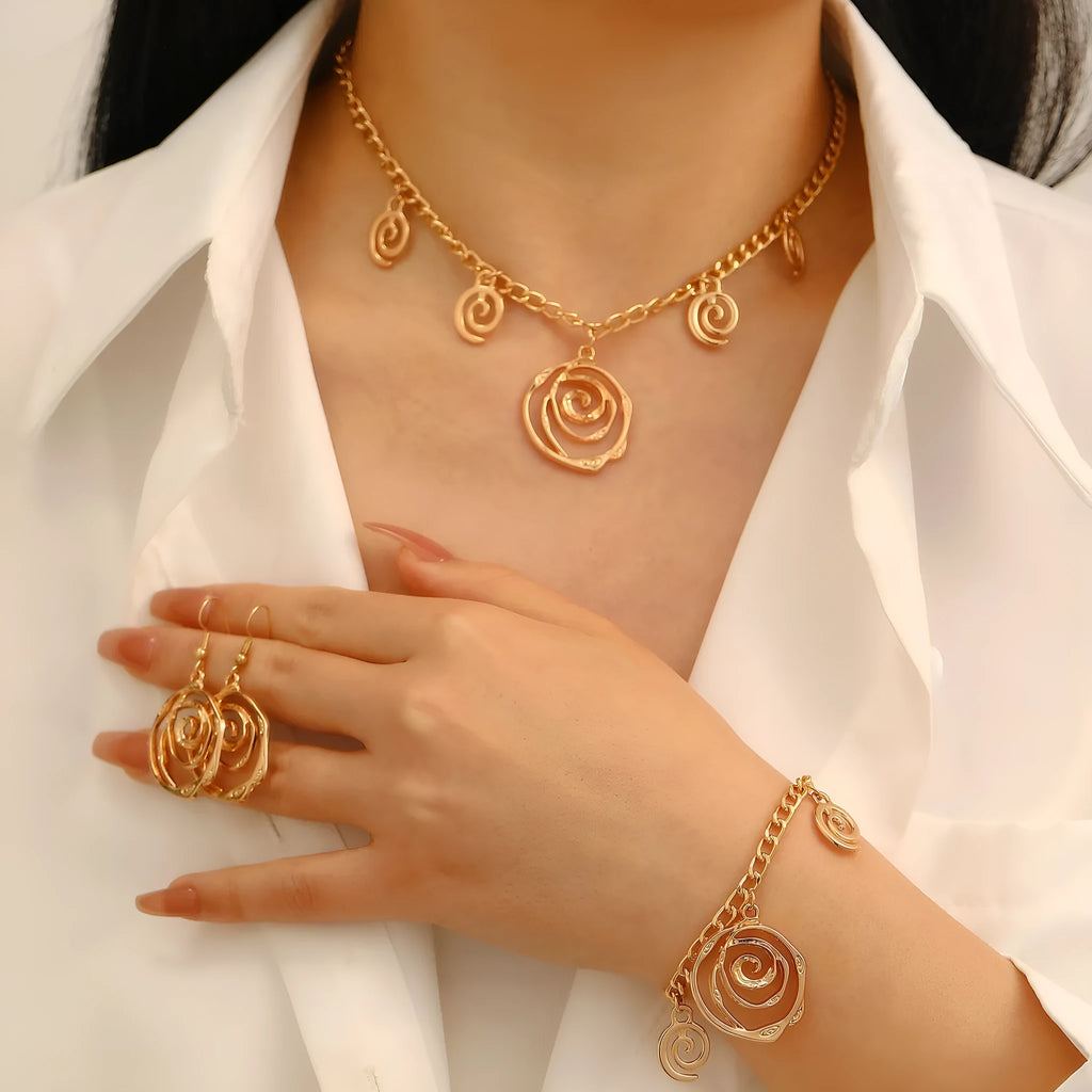 Geometric spiral donut jewellery set showing necklace, bracelet, and earrings in gold electroplated finish