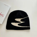 Acrylic thermal knit beanie hat in black on a white background, showing ribbed texture.