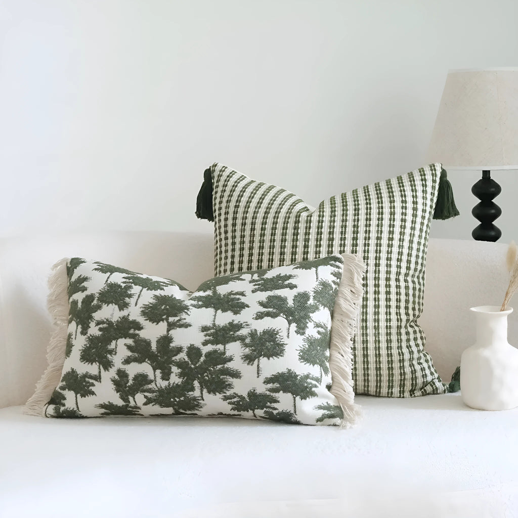 Green decorative pillow with tassel or beaded design on a cotton linen blend cover.