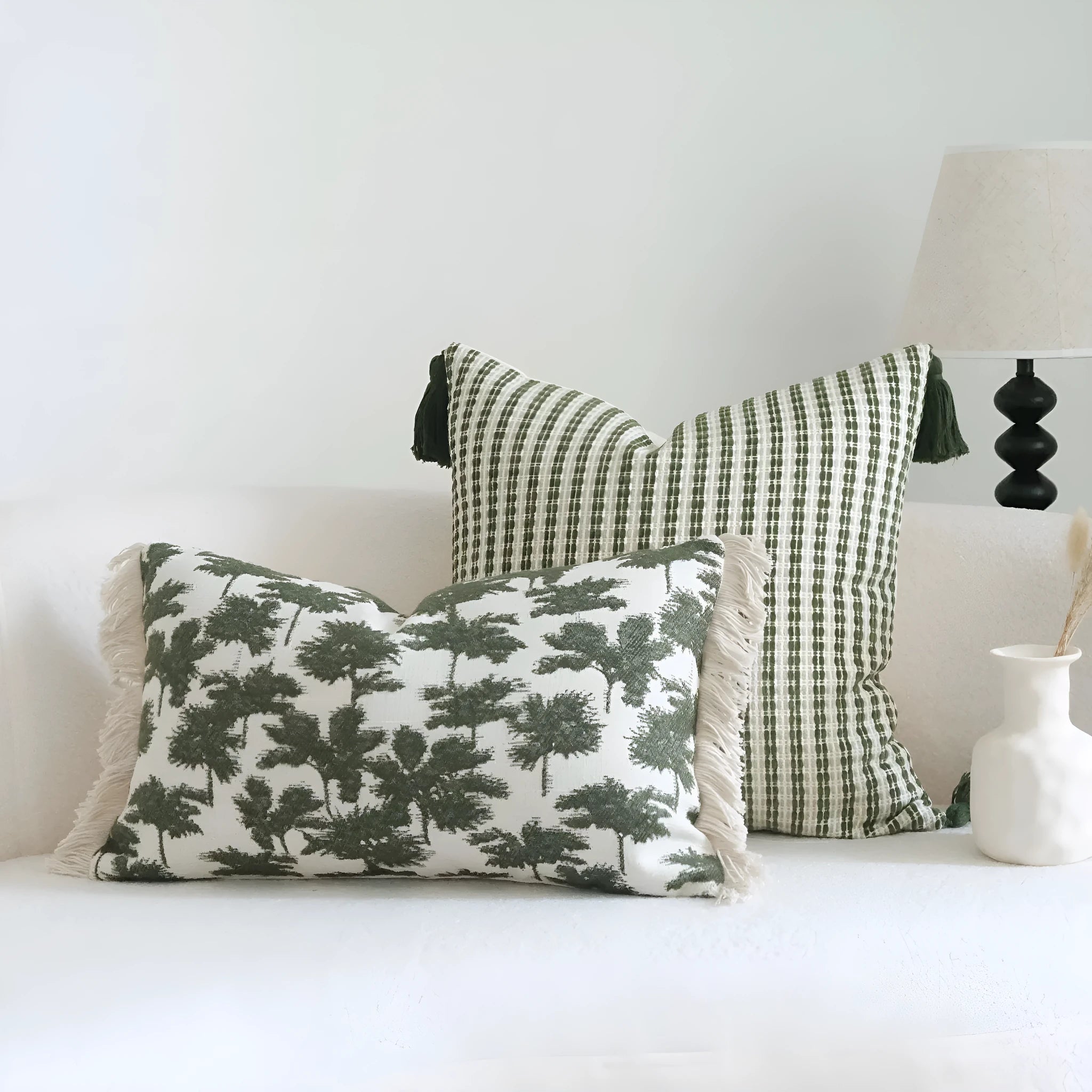 Green decorative pillow with tassel or beaded design on a cotton linen blend cover.