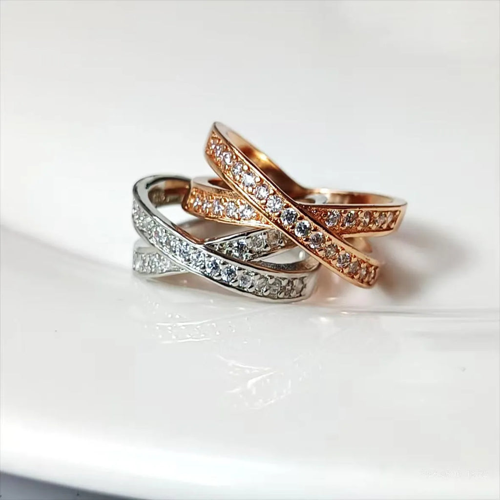 A silver or rose gold metal ring featuring a cross design with micro-inlaid zircon stones, shown in sizes 6 to 9.