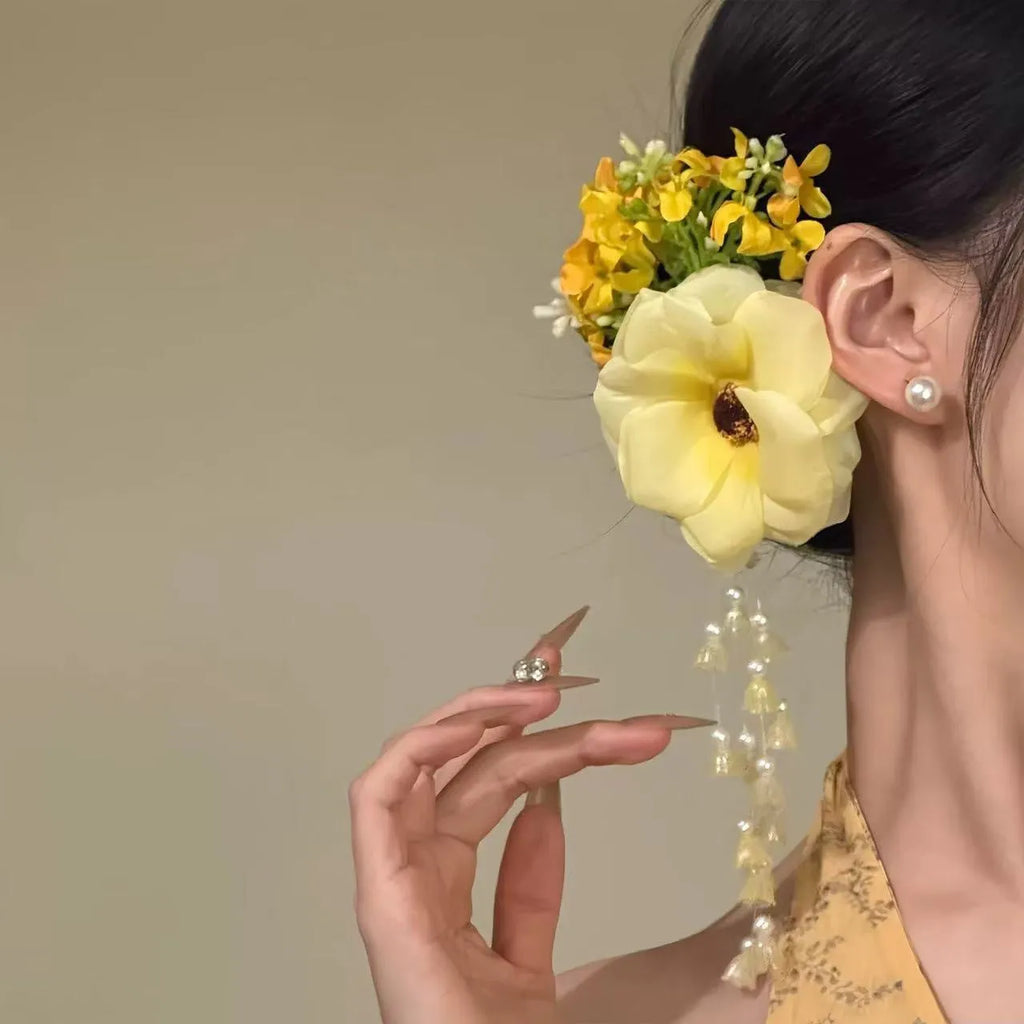 Close-up of a women's floral tassel hair clip with a side clip, shown in yellow and purple colour options.