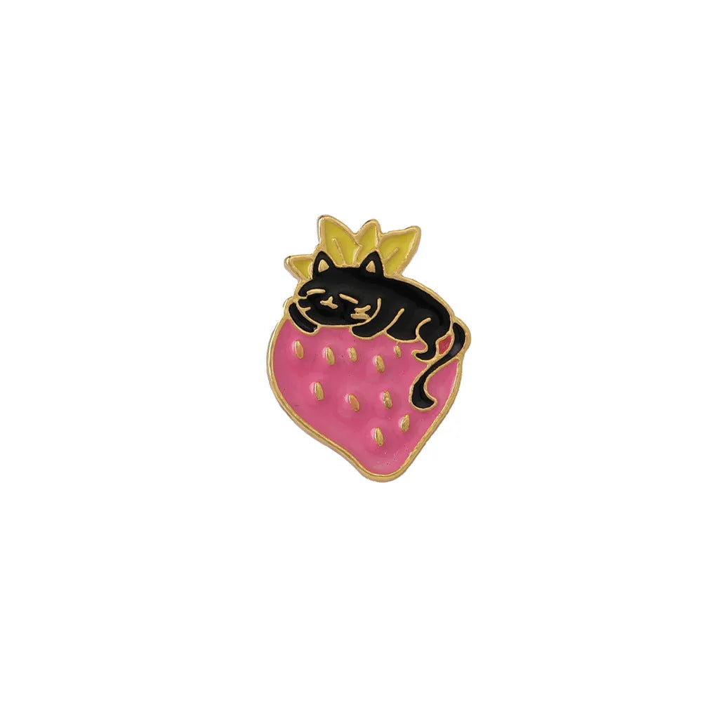 Close-up of a cute cat strawberry dripping oil cake design alloy metal brooch on a fabric background.