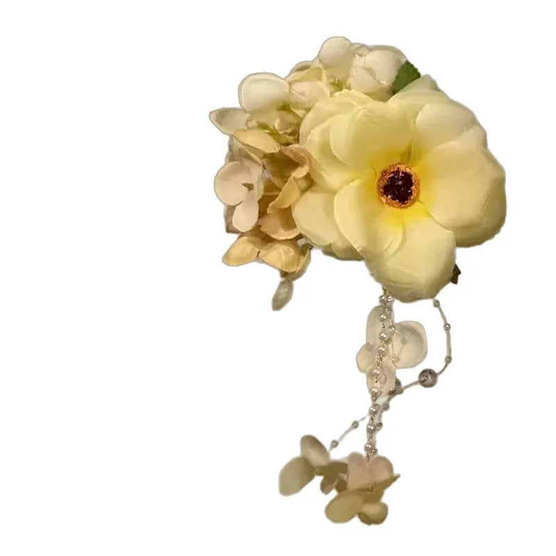 Close-up of a women's floral tassel hair clip with a side clip, shown in yellow and purple colour options.