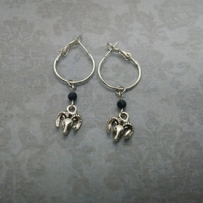 A pair of silver-coloured alloy round ring hoop earrings on a plain background.