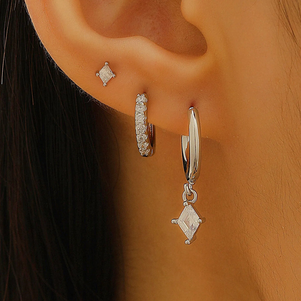 Women's three-piece geometric zircon earring set in gold showing pendant, stud, and clip-on styles