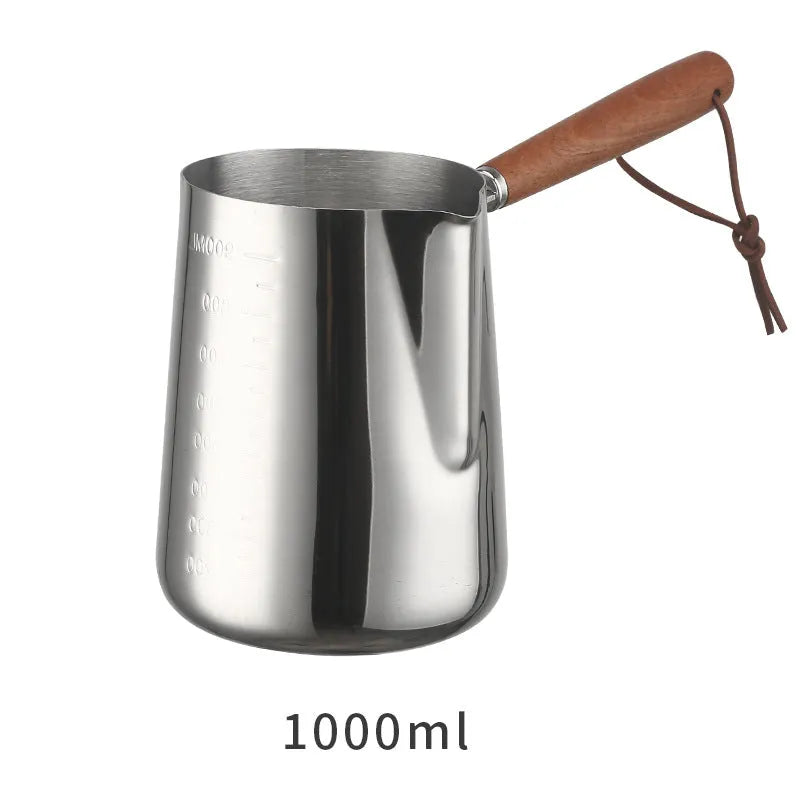 Stainless steel coffee milk jug with wooden handle and measuring scale for latte art.