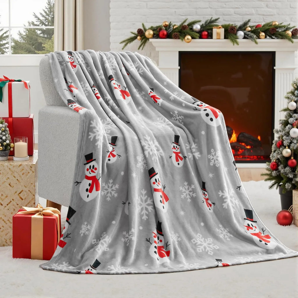Soft red polyester flannel Christmas blanket draped over a sofa, showing its plush texture and generous size.