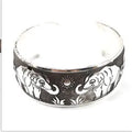 Open cuff bracelet with carved ethnic Miao silver design in alloy material