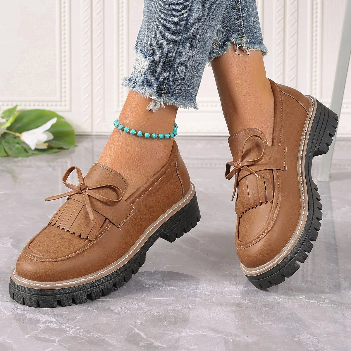 Black faux leather women's loafers with a tassel decoration and a thick chunky heel